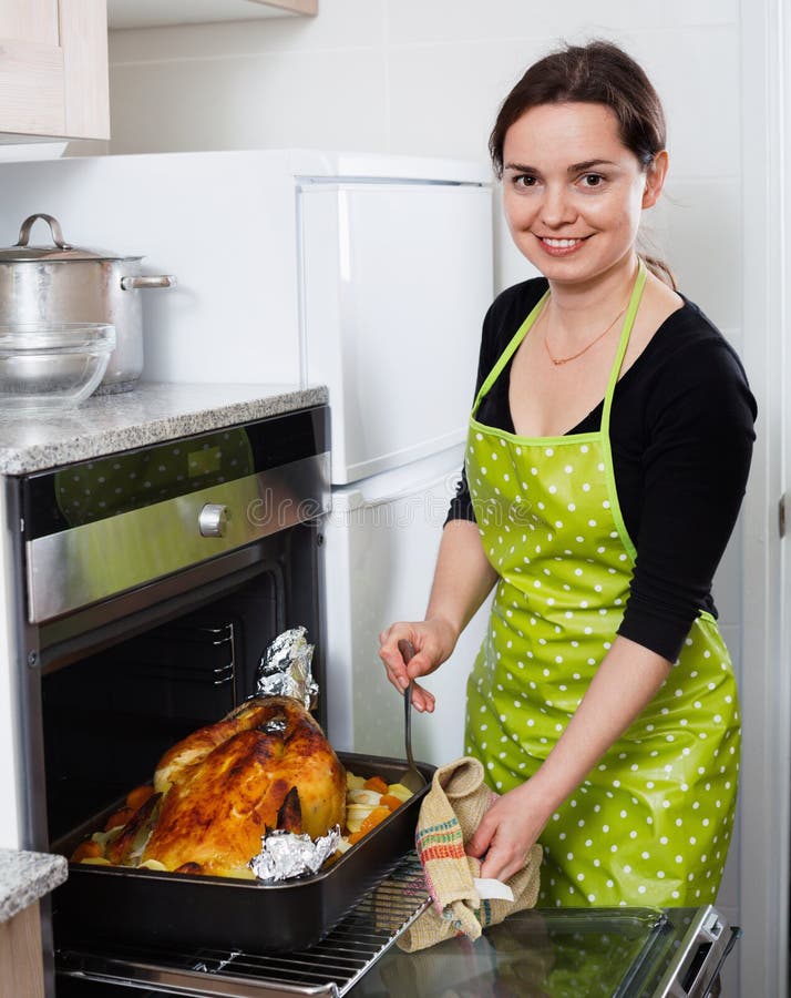 smiling cheerful woman roasting cockerel